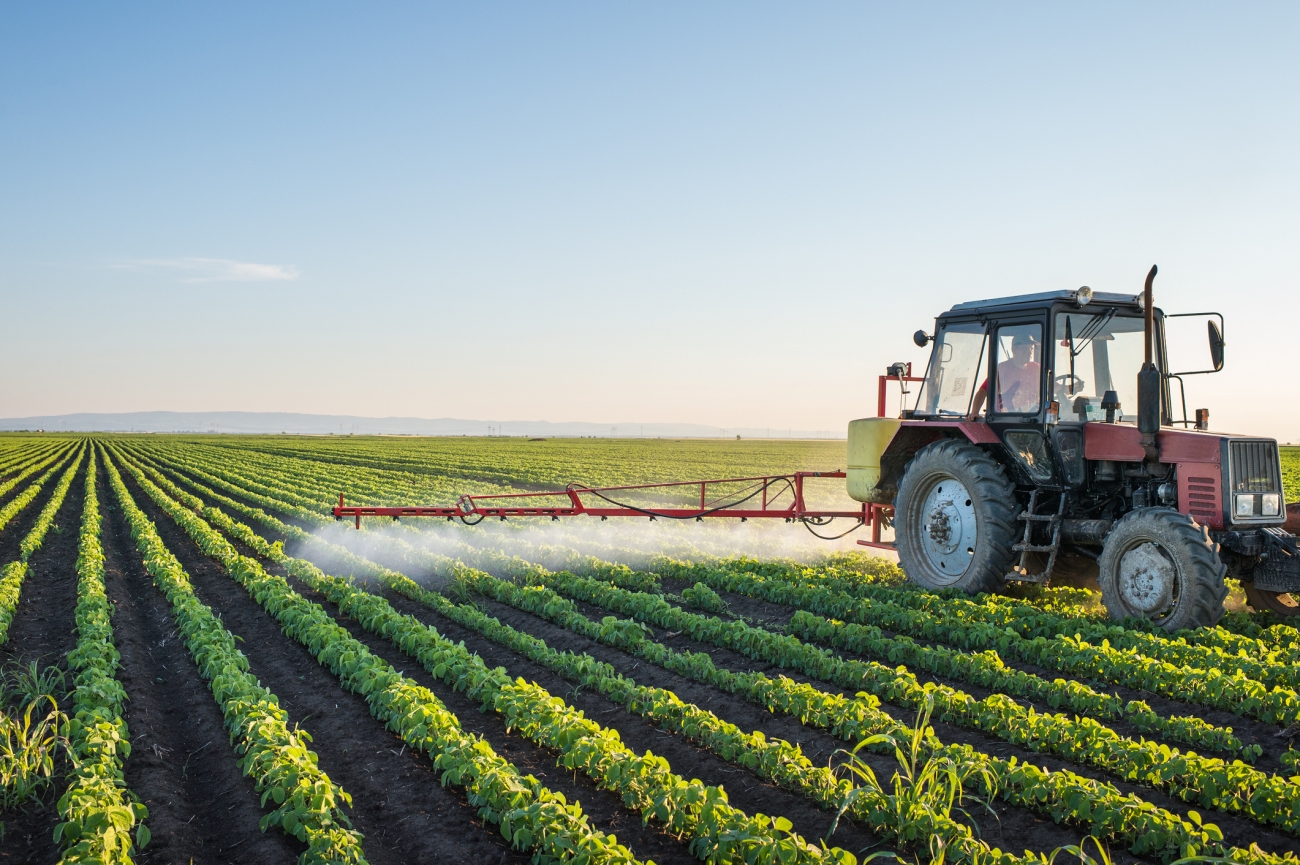 truck spraying crop with pesticides
