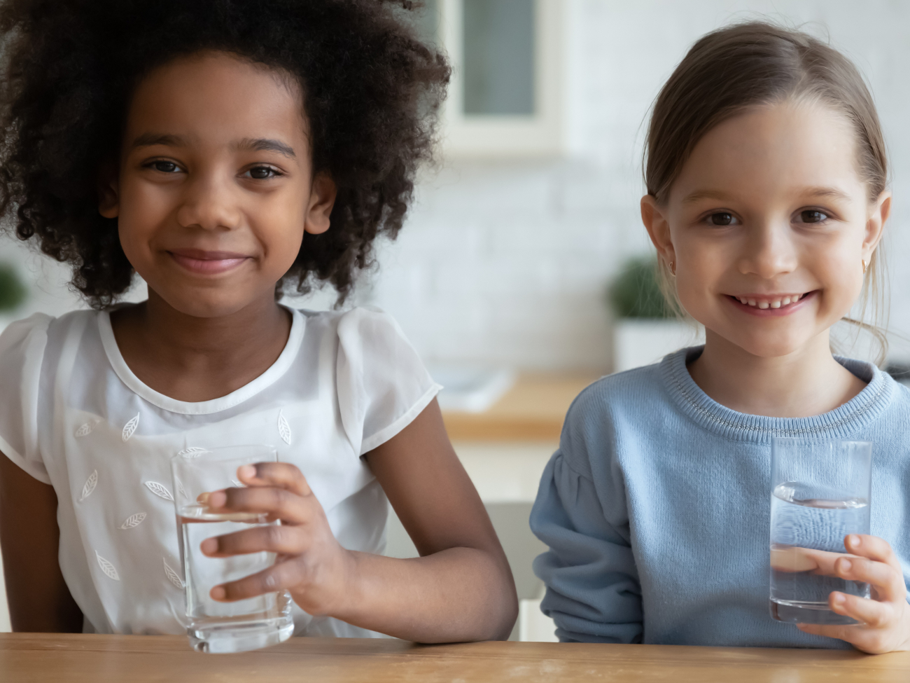 girls smiling holding water glasses